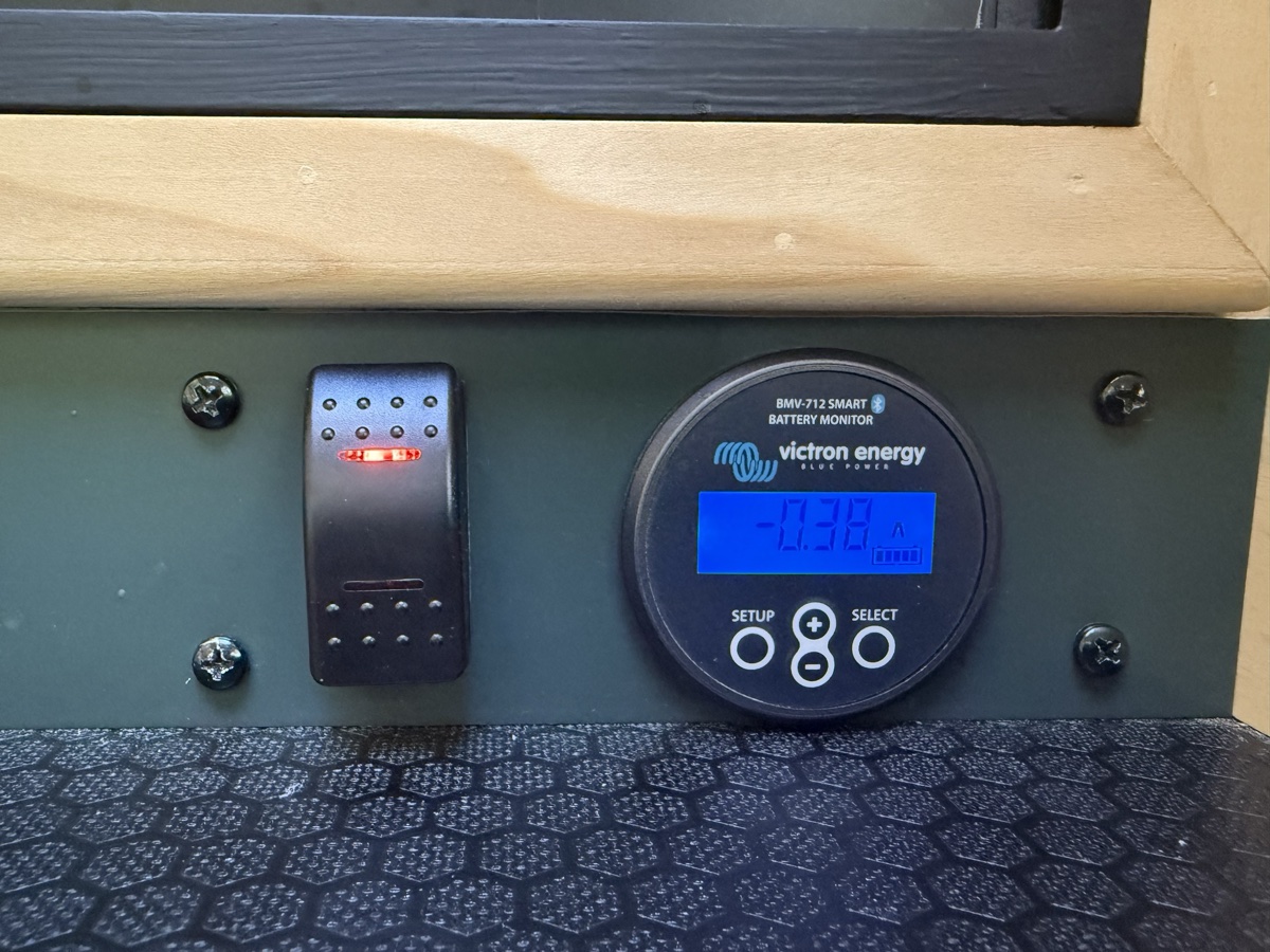 A lit rocker switch beside a Victron BMV-712 battery monitor reading minus 0.38 amps